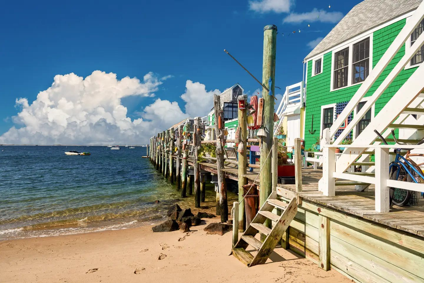 A green building sitting on the beach next to the ocean